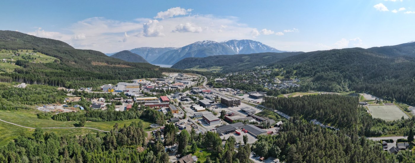 Flyfoto over Kaupanger næringsområde med fjord og fjell i bakgrunnen